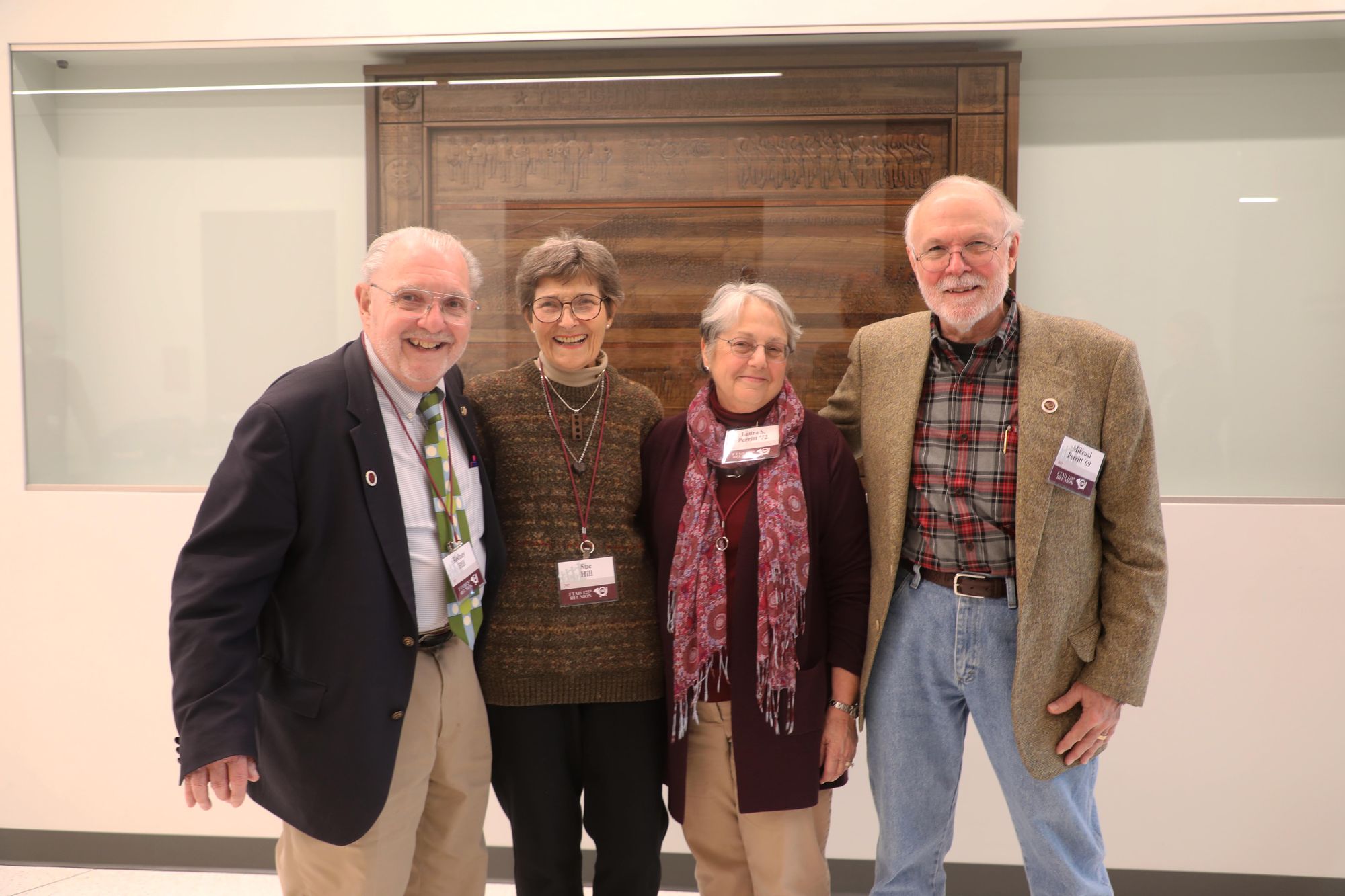 Rodney Hill, Sue Hill, Laura Perritt and Mikeual Perritt stand in front of the wood panel