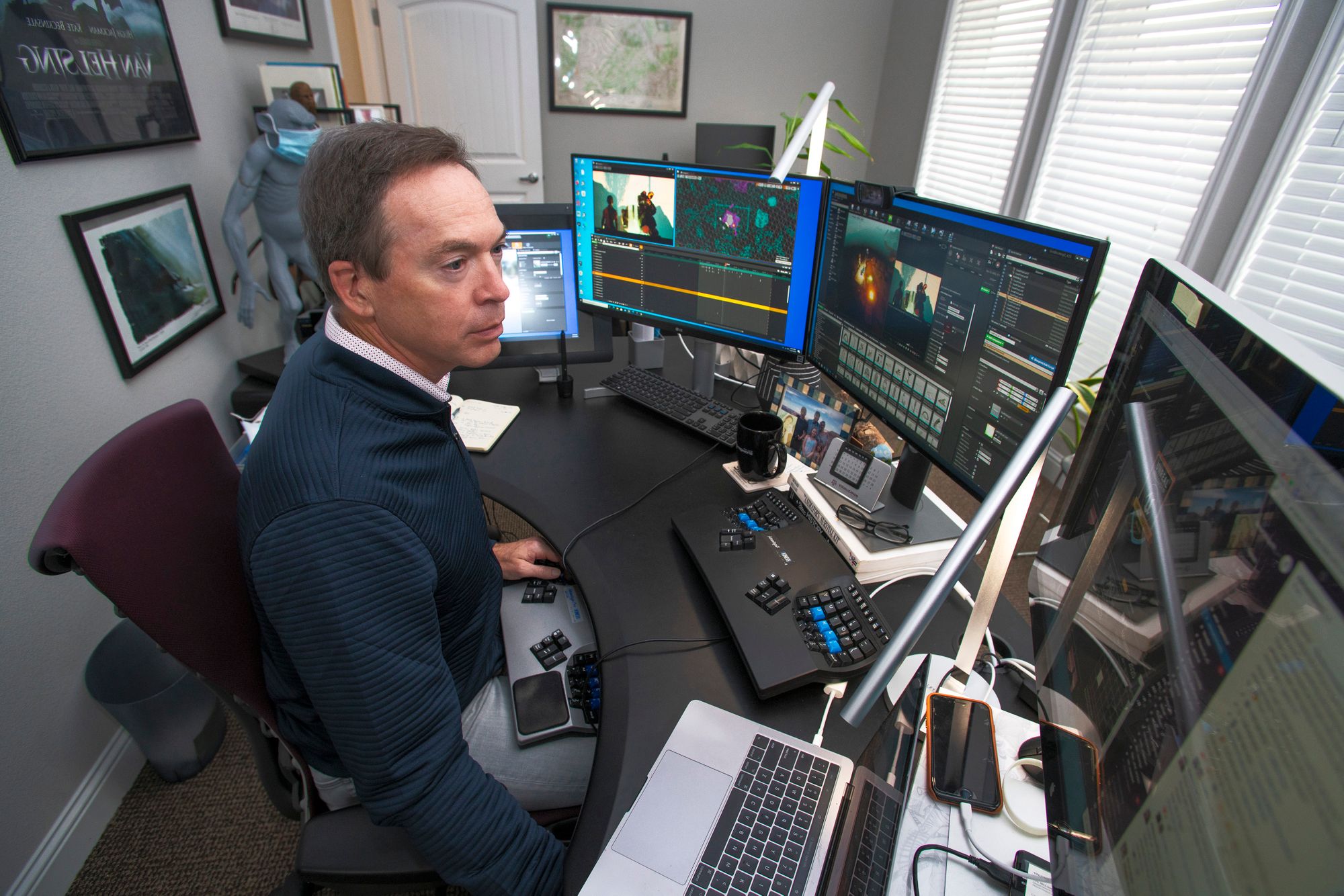 Tim McLaughlin sitting at his desk in front of a large computer, known as a Dell 5820. 
