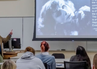 Professor lecturing on a black and white movie