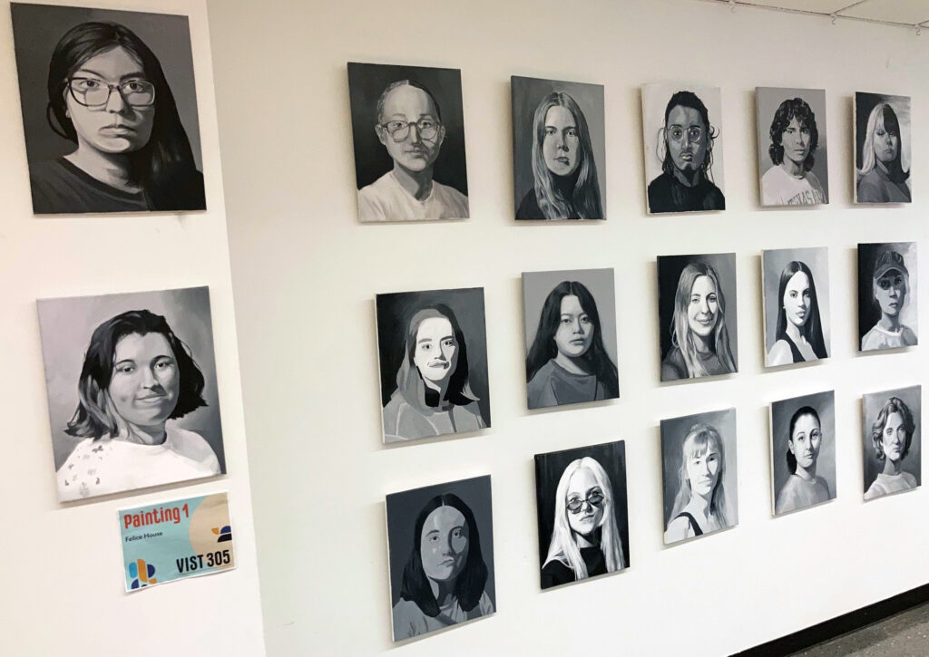A series of portraits is displayed on a wall.