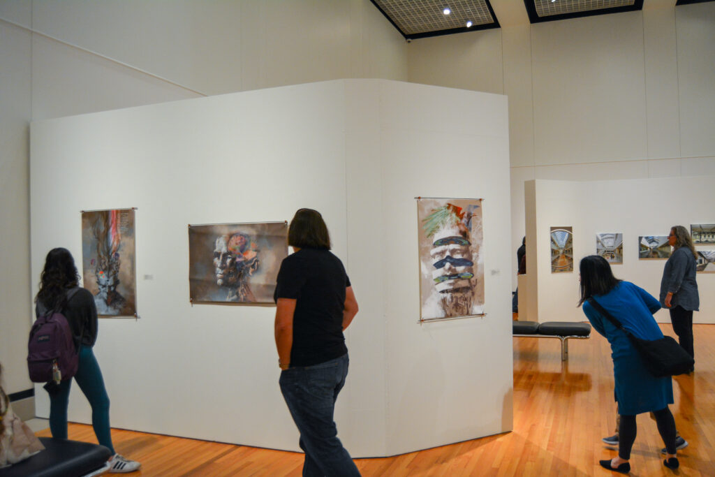 Guests examine various forms of artwork on a gallery's walls.