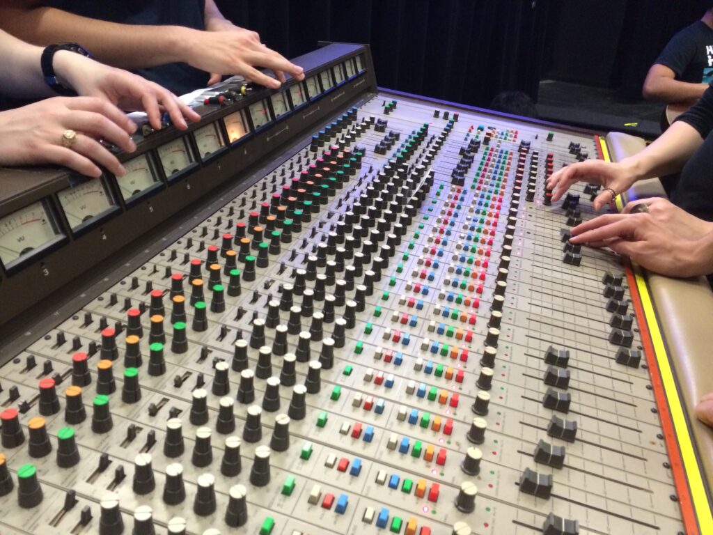 A close-up image of students working with music studio equipment