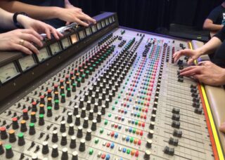 A close-up image of students working with music studio equipment