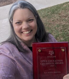 A smiling woman holds an award in her hands.