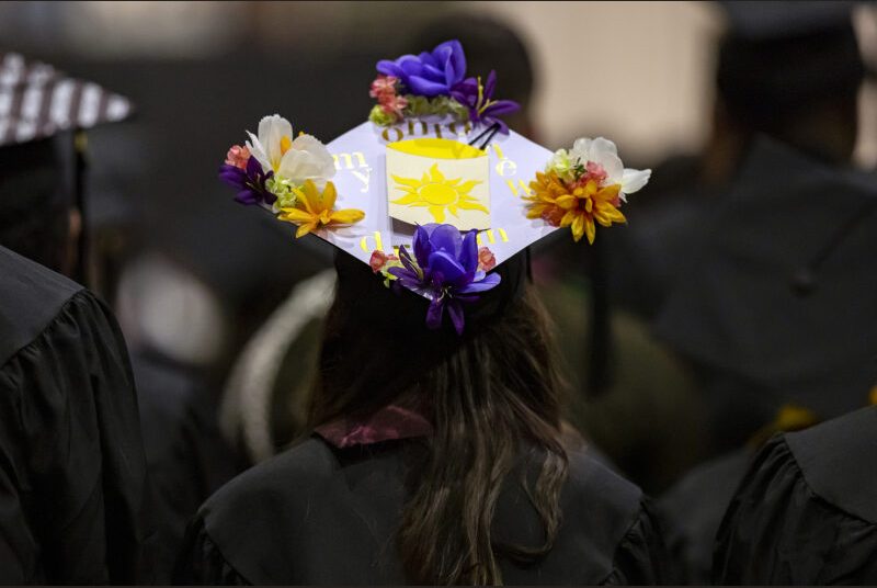 A graduating college student with a decorated graduation cap.