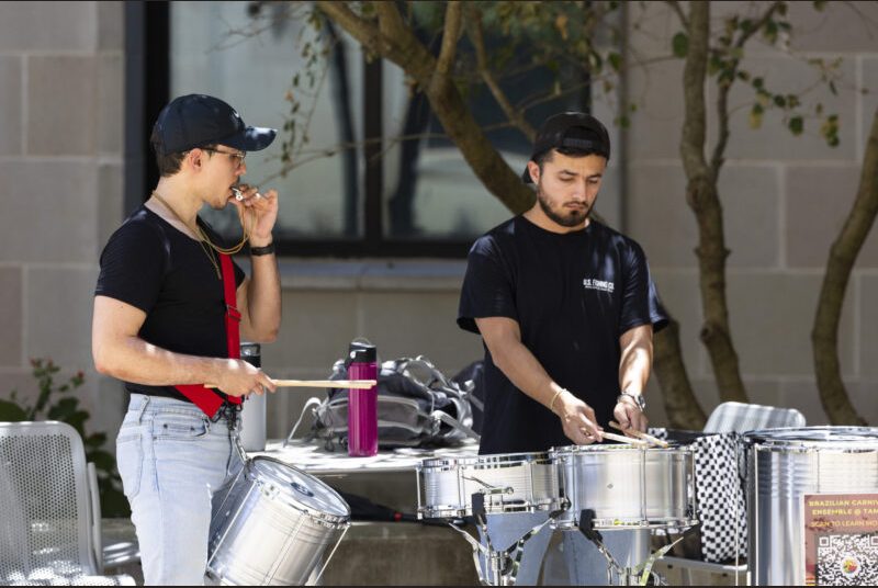 A percussion ensemble performs in an outdoor setting.