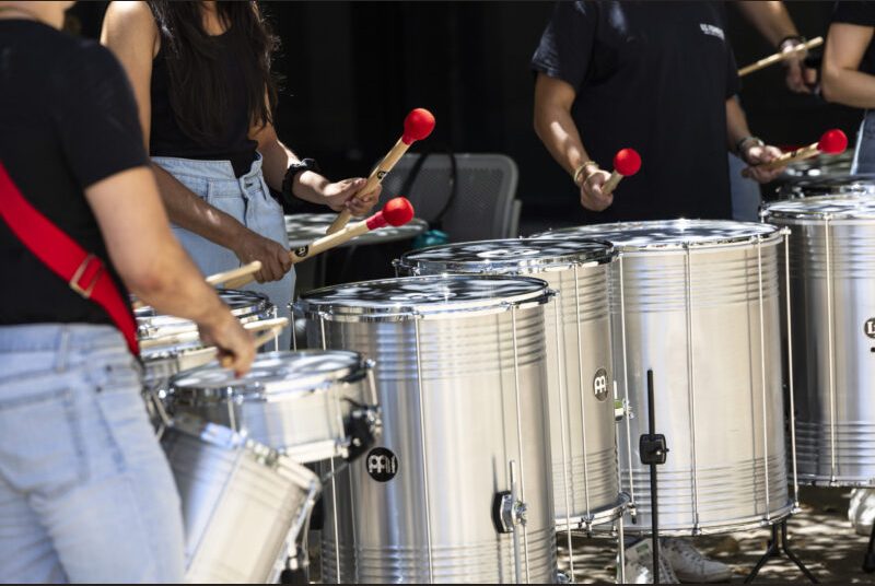 A percussion ensemble performs in an outdoor setting.