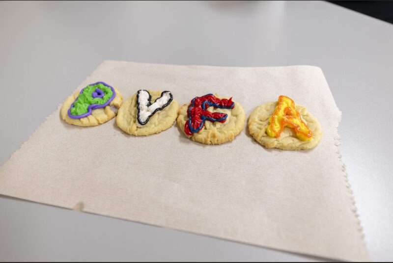 Four decorated cookies spell out 