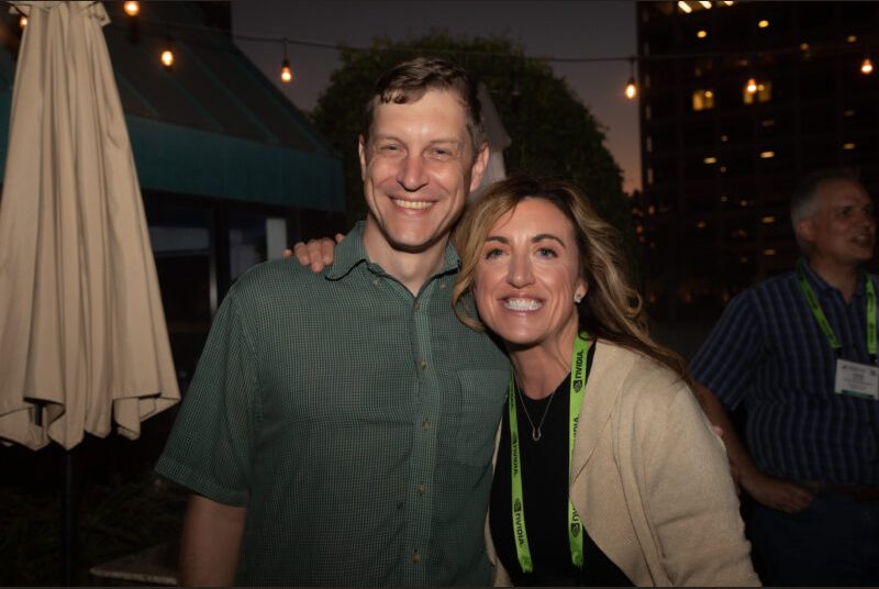 Two people smile for a photo at a party