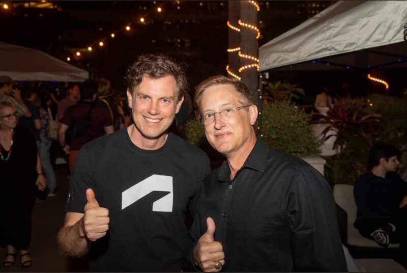 Two people smile for a photo at a party