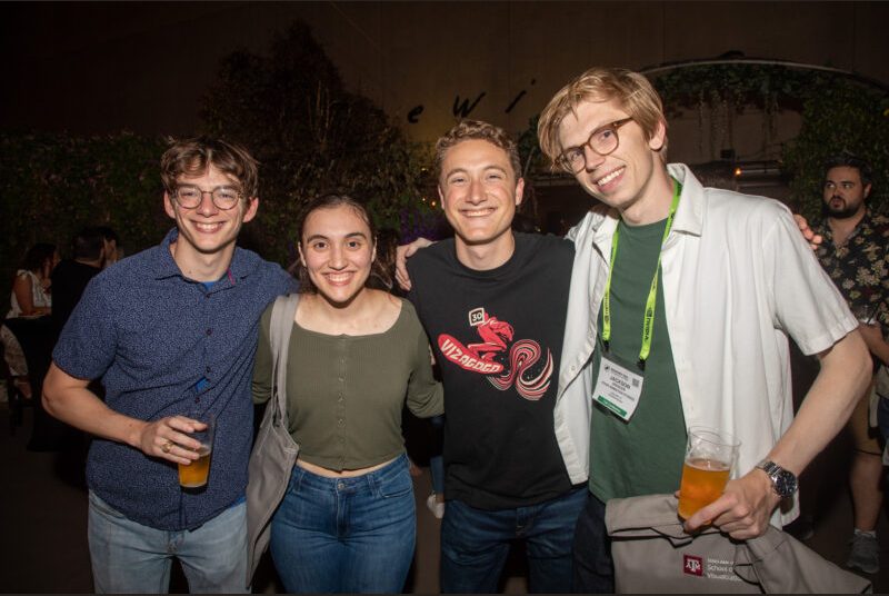 Four people smile for a photo at a party