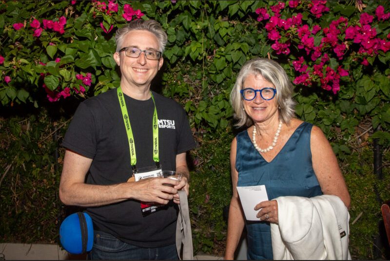 Two people smile for a photo at a party