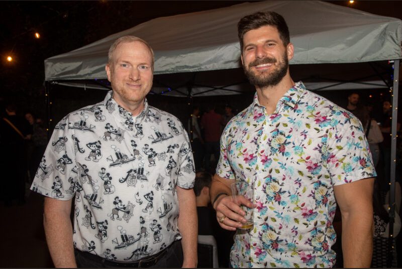 Two people smile for a photo at a party