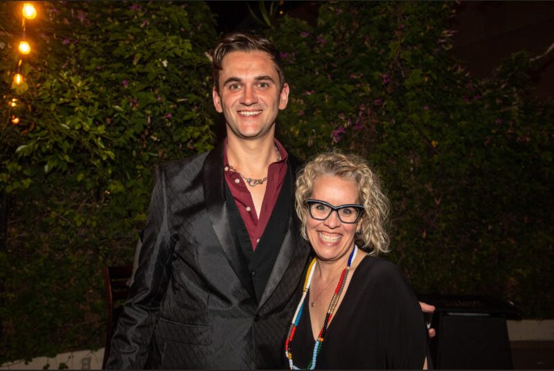 Two people smile for a photo at a party