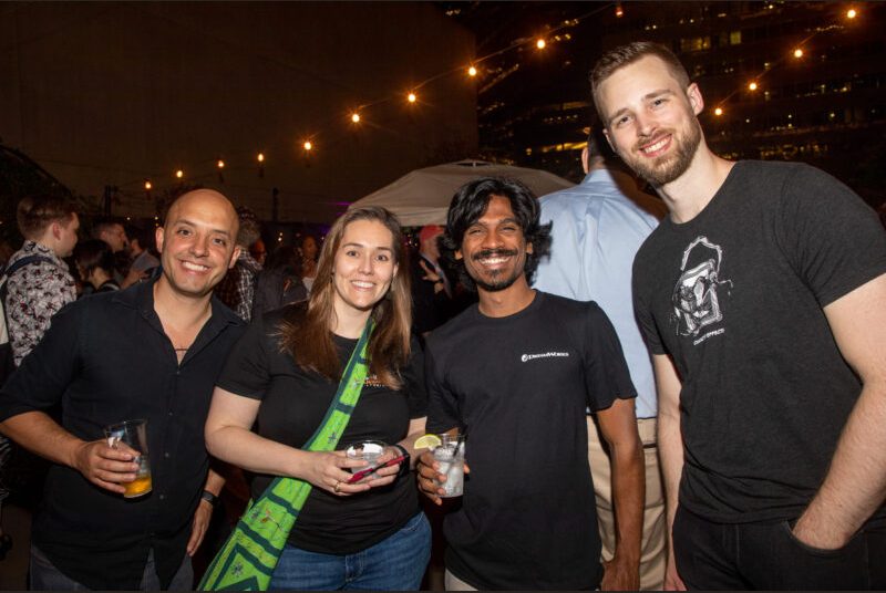 Four people smile for a photo at a party