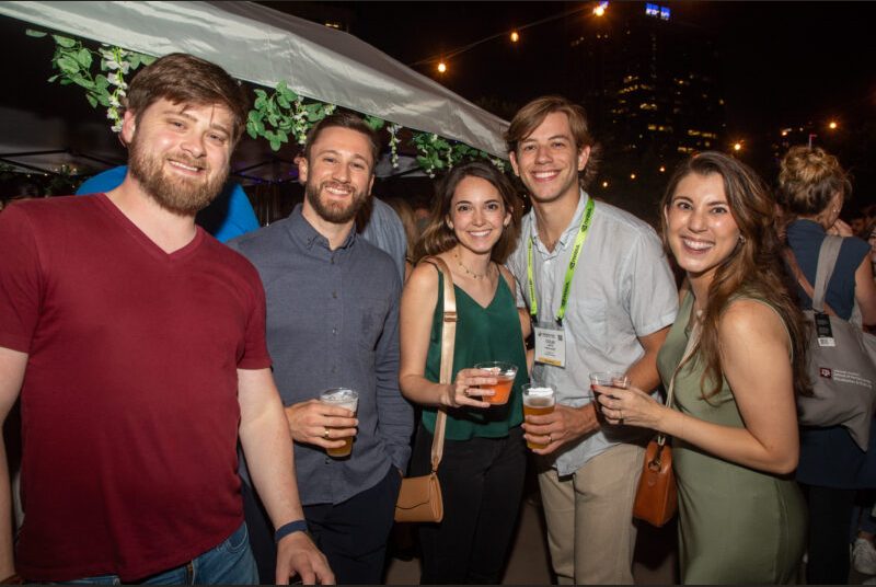 Five people smile for a photo at a party