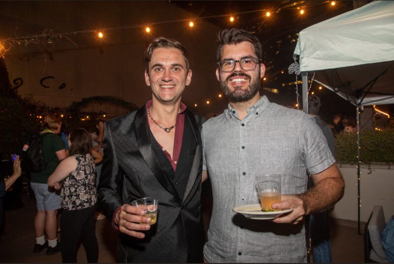 Two people smile for a photo at a party