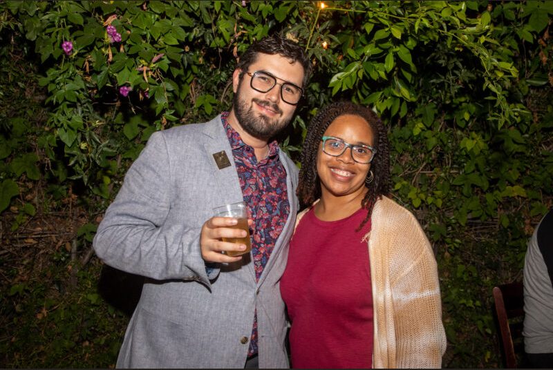 Two people smile for a photo at a party