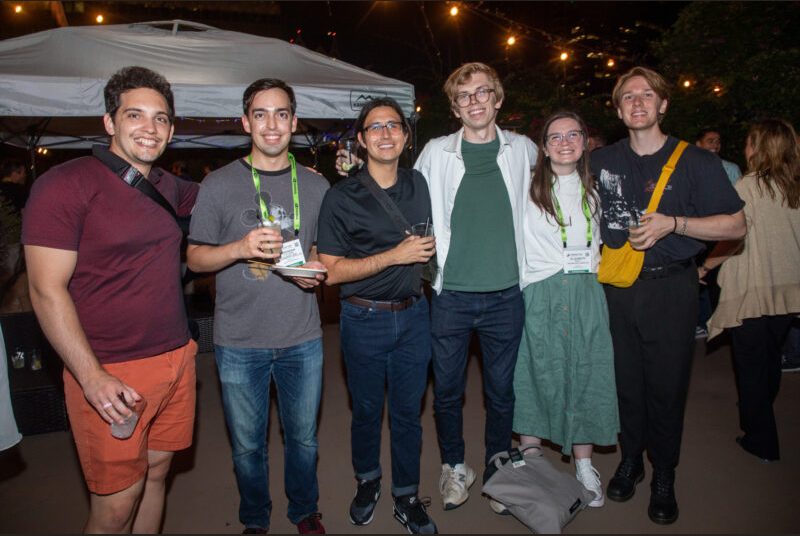 Six people smile for a photo at a party