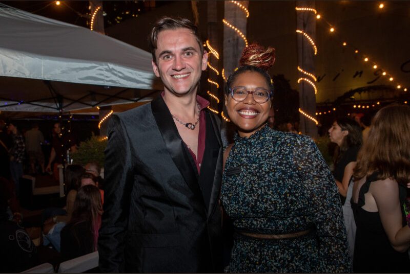 Two people smile for a photo at a party