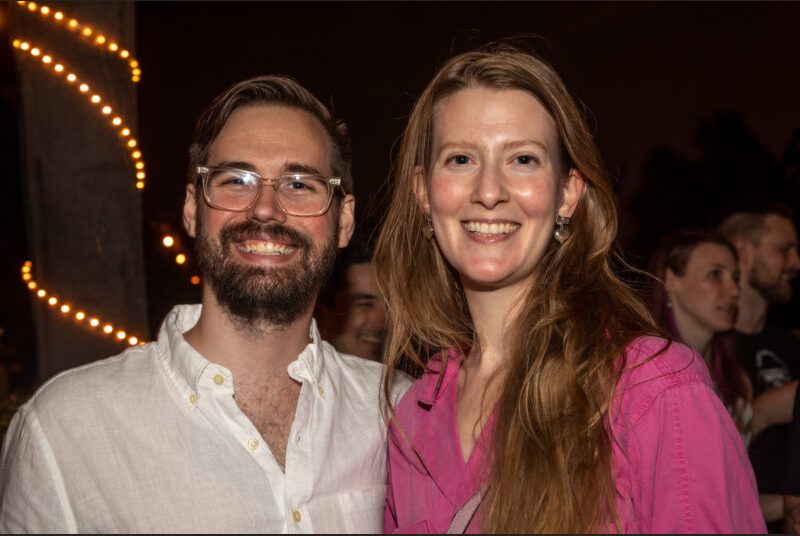 Two people smile for a photo at a party