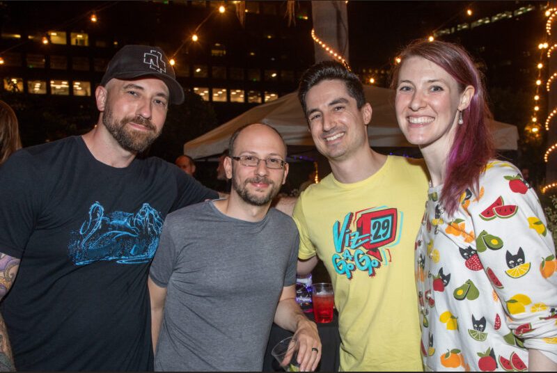 Four people smile for a photo at a party