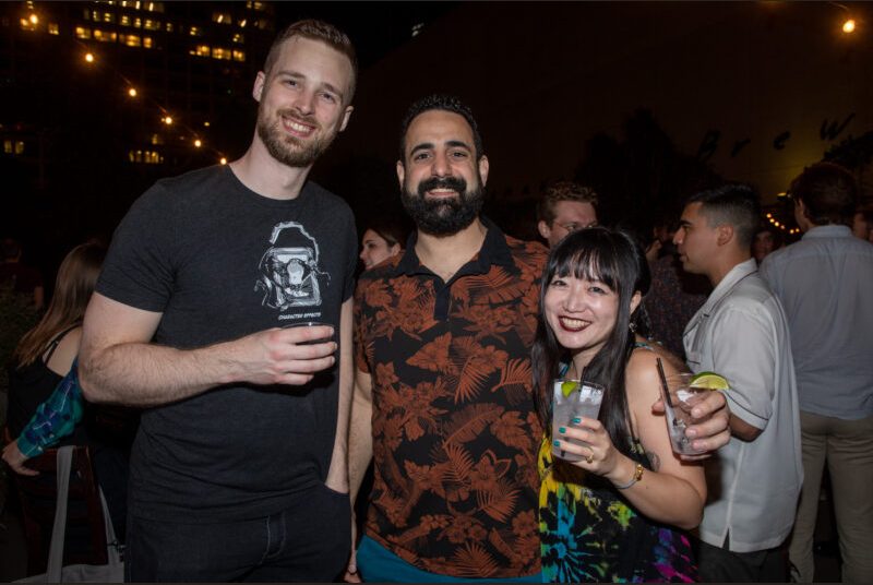 Three people smile for a photo at a party