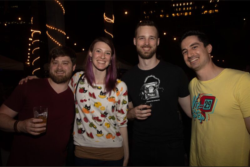 Four people smile for a photo at a party