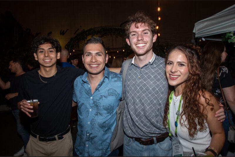 Four people smile for a photo at a party