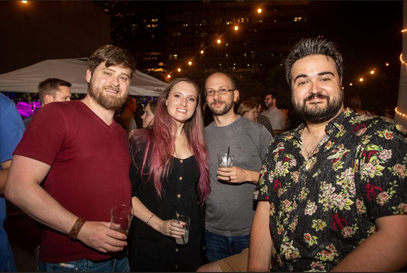 Four people smile for a photo at a party