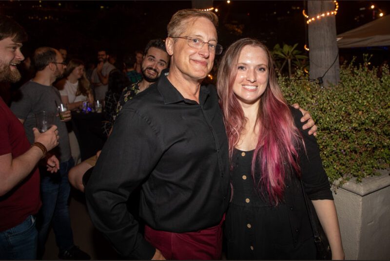 Two people smile for a photo at a party