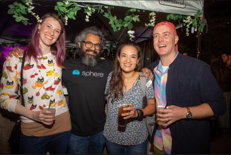 Four people smile for a photo at a party