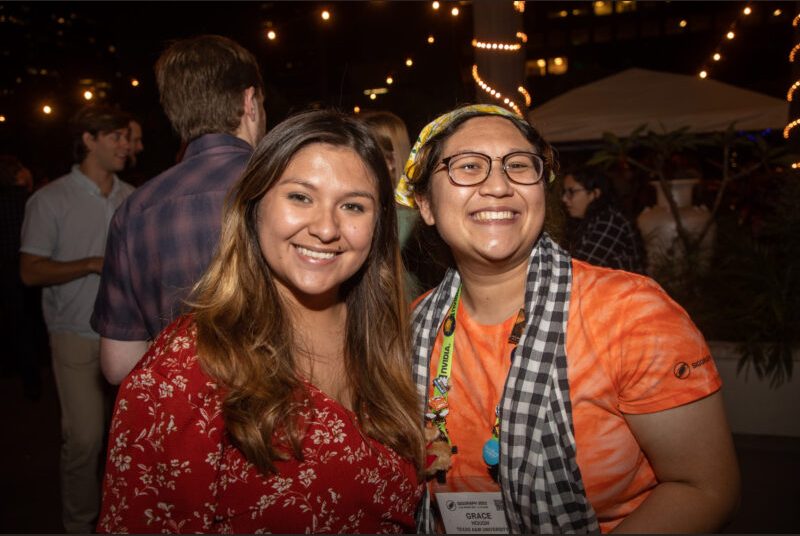 Two people smile for a photo at a party