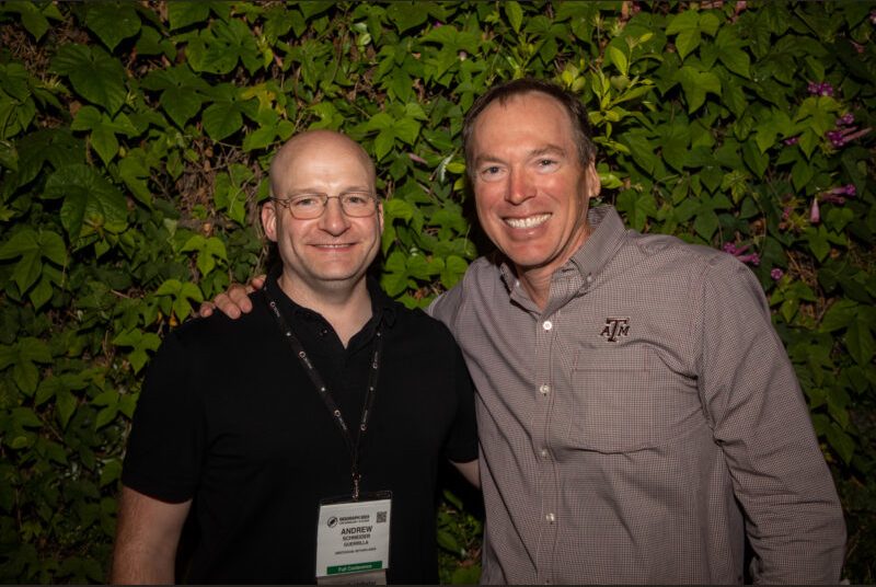 Two people smile for a photo at a party