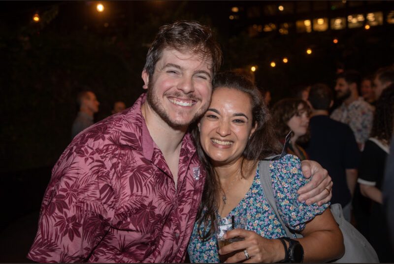 Two people smile for a photo at a party