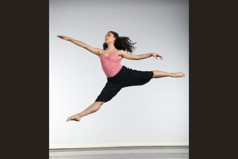 Choreographer Melanie Diaz is shown leaping in the air