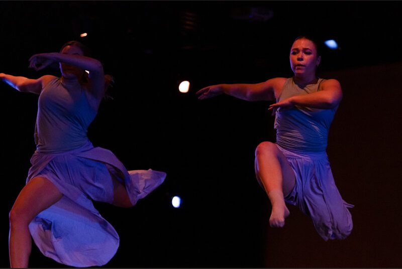 Two dancers leap through the air.