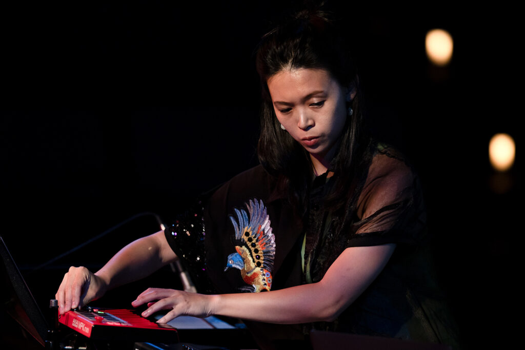 An artist uses a synthesizer in a performance.