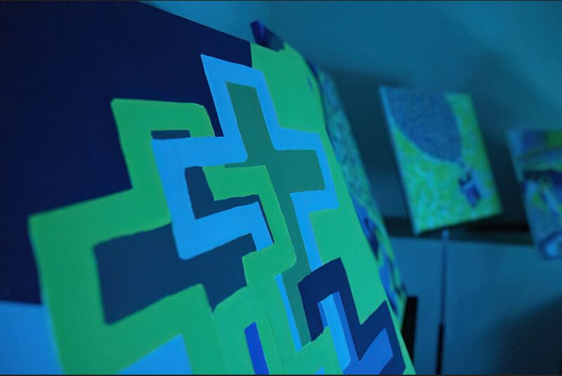 Several abstract paintings are shown, surrounded by a blue light.