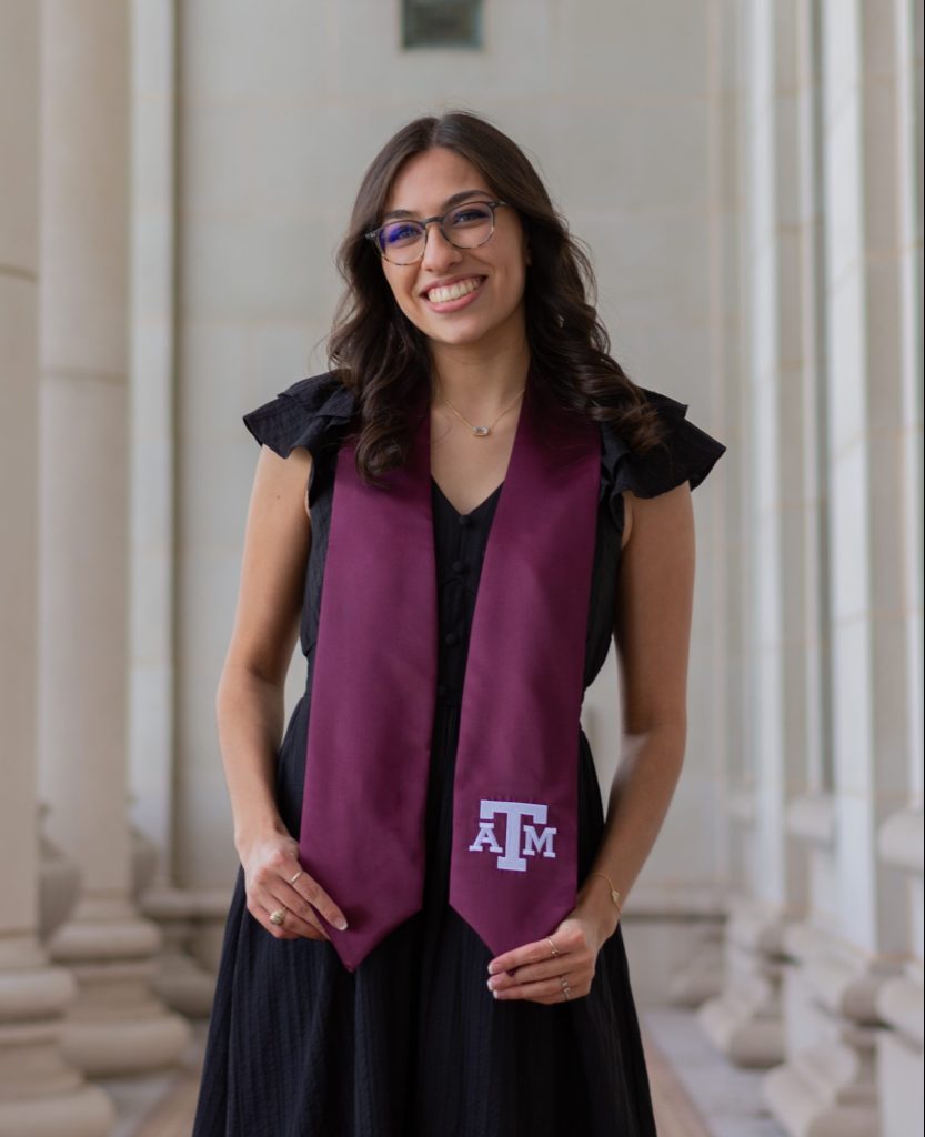 A college student wears a maroon Texas A&M graduation sash.