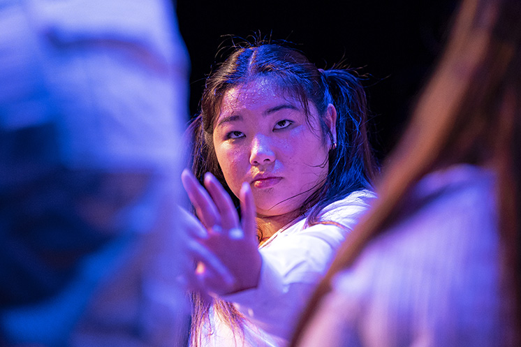 A closeup view of a college dance student in the midst of a performance.