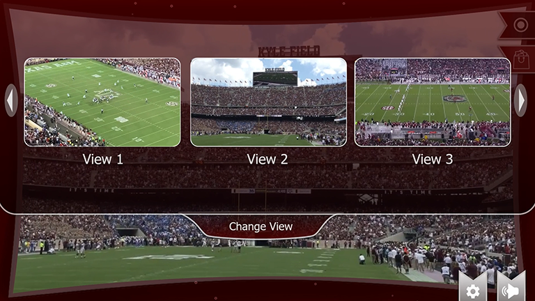 A head-up display with Texas A&M-themed graphics in maroon and white, featuring an Aggie football game. A menu is pulled down, offering alternate views from 1 to 3.