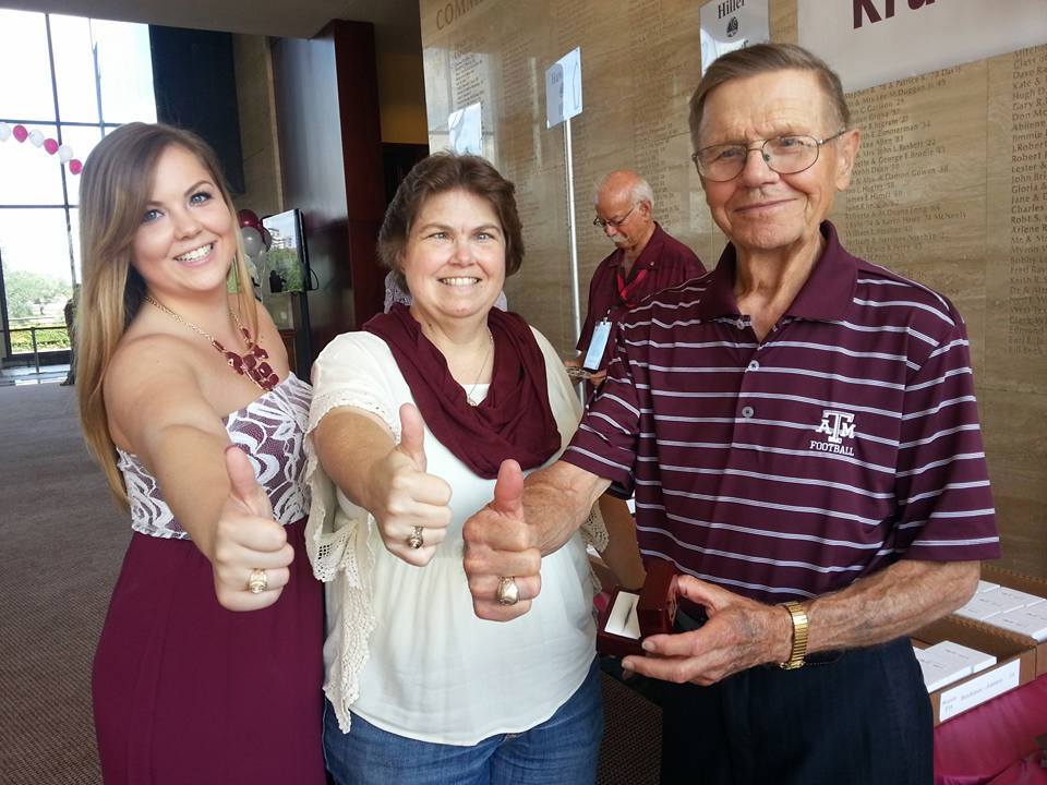 Three people smile and give the thumbs-up gesture.