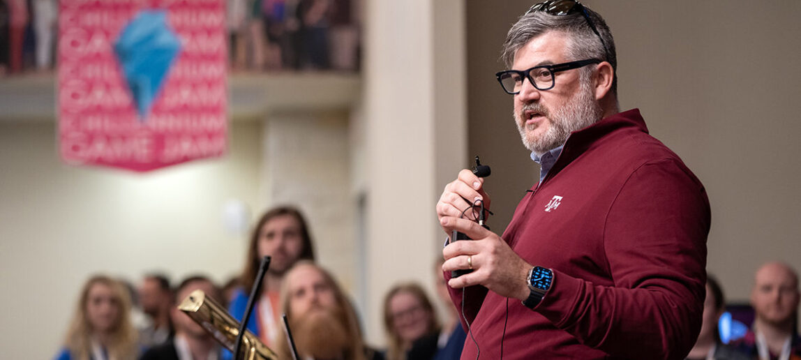 A university professor addresses a crowd of students at a 48-hour game jam.