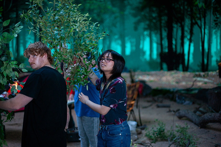 College students hold plant props for a short film being shot on a virtual production stage.