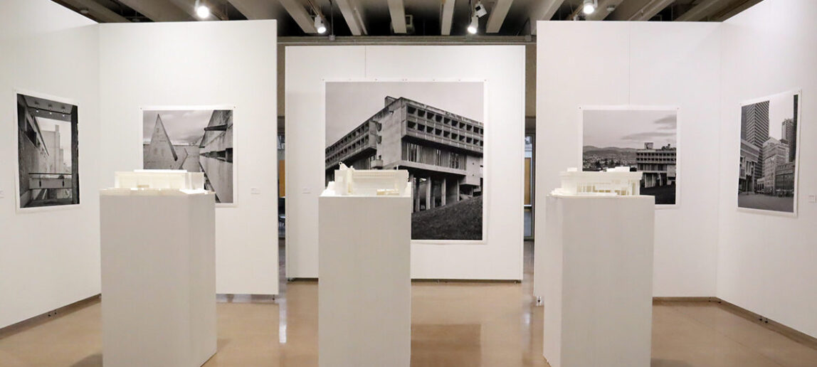 An art gallery features several black and white photographs of brutalist architecture examples.