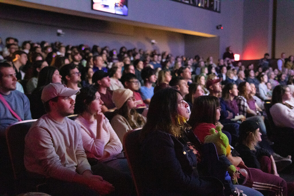 People gather in a theater to view a screening.