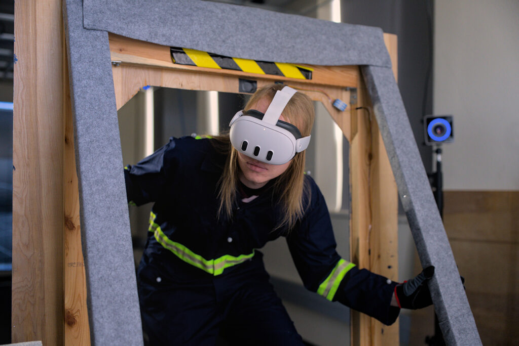 A student wears an augmented reality headset device as he steps through a simulated environment.