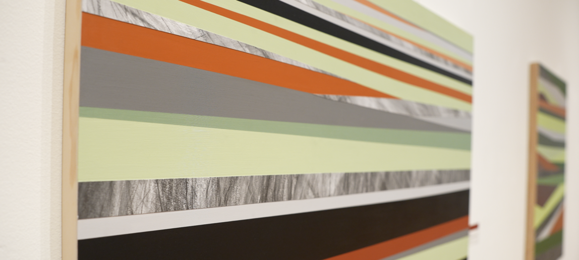 A piece of abstract art with orange, black and green colors.